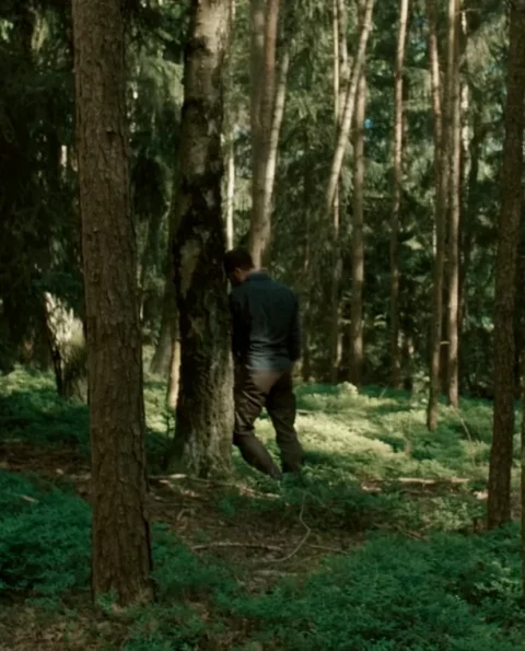 Naturverbindung symbolisiert durch einen Mann, der im Wald an einem Baum lehnt